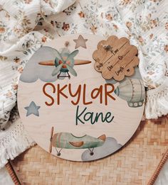 a wooden sign that says skylor kanee on it with an airplane in the background