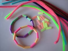 several different colored bracelets on a white surface