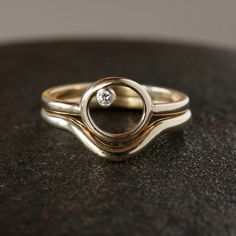 Made of solid 14k gold, this modern, minimalist wedding band is the perfect compliment to your engagement ring. A sweeping curve allows this ring to stack with a diamond ring that projects outwards at the center. The band measures 1.7mm thick and 2mm wide, and has a rounded profile. This ring is available in either 14k rose gold or 14k yellow gold. If you are at all unsure of the ring size, please purchase this easy, reusable finger sizer before you order the ring: https://www.etsy.com/listing/1 Minimalist Curved Wedding Rings, Minimalist 14k Gold Wedding Ring With Tension Setting, Modern 14k Gold Stackable Rings With Single Diamond, Modern Single Diamond Wedding Ring, Modern Curved Jewelry For Wedding, Modern Curved Wedding Jewelry, Minimalist Polished Diamond Wedding Ring, Modern Promise Ring, Modern Curved Wedding Rings