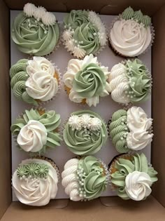 a box filled with cupcakes covered in green frosting and white icing