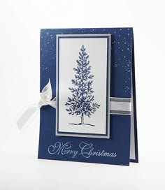 a blue christmas card with a white ribbon on the side and a tree drawn on it