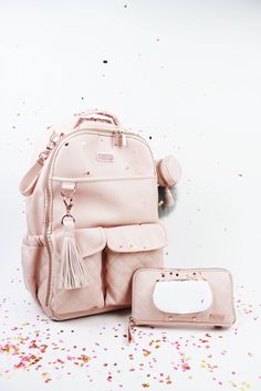 a pink backpack and matching purse with confetti sprinkles on the floor