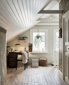 an attic with white walls and wood floors