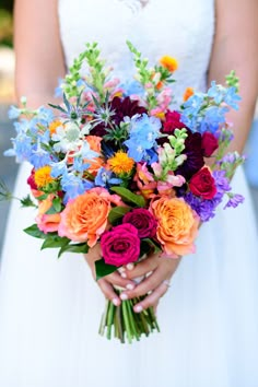 a bride holding a bouquet of colorful flowers