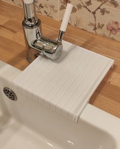 a sink with a soap dispenser next to it on a wooden counter