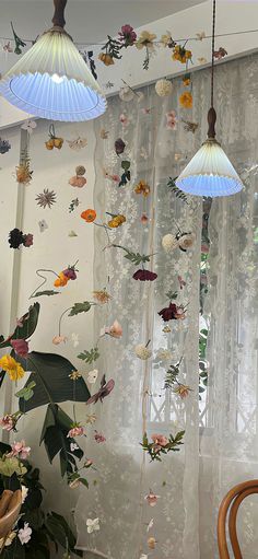 some lights hanging from the ceiling in front of curtains with flowers and butterflies on them