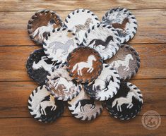 several plates with horses on them sitting on a wooden table