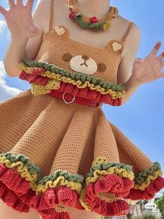 a woman wearing a dress made to look like a teddy bear with her hands in the air