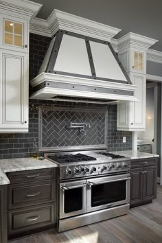 a stove top oven sitting inside of a kitchen next to white cabinets and counter tops