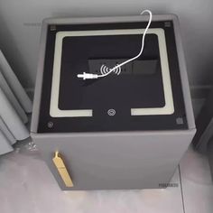 an electronic device is attached to the side of a wall with wires and magnets on it