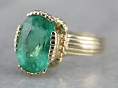 This vintage emerald ring is a simple, and quite a versatile piece with clean lines and great proportions. This ring is classic and traditional, featuring a solid gold head to hold the stone securely. The beautiful emerald has a shade of green that is just the same as the brightest springtime leaves. Metal: 14K Yellow Gold Gem: Emerald 4.08 Carats Gem Measurements: 12.1 x 8.5 mm, Oval Ring Size: 6 Marks: "KIMBERLY 14K" Stamped on the inside band Classic Signet Ring With May Birthstone, Vintage Emerald Ring With Prong Setting, Antique Style Emerald Cut Emerald Ring With Prong Setting, Timeless Green Emerald Ring With Bezel Setting, Timeless Bezel-set Emerald Ring For May Birthstone, Timeless Emerald Ring With Bezel Setting For May Birthstone, Timeless Oval Emerald Ring With Bezel Setting, Timeless Bezel Set Emerald Ring For May Birthstone, Timeless May Birthstone Emerald Ring With Bezel Setting