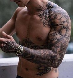 a man with tattoos on his arm holding a cell phone