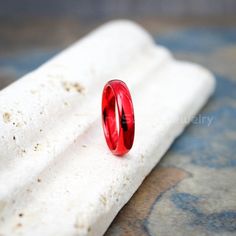 a red ring sitting on top of a white piece of paper