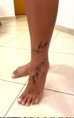 a woman's foot with leaves on it and the bottom part of her leg