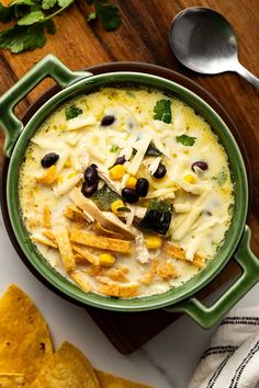 a green bowl filled with chicken tortilla soup