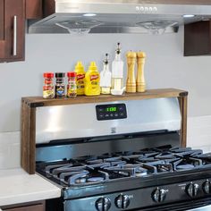 an oven with spices and condiments on the shelf above it in a kitchen