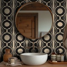 a bathroom vanity with a round mirror above it and decorative wallpaper on the walls