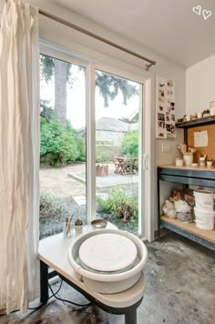 a kitchen with lots of pots and pans on the counter top in front of a sliding glass door