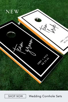 two cornhole game boards sitting on top of green grass