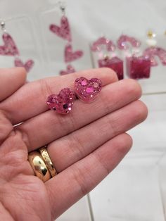 These are a pair of pink glitter resin heart shaped stud earrings. The stud is made of nickel free metal. Pink Heart Resin Earrings, Pink Resin Heart Earrings As Gift, Pink Resin Heart Earrings For Gift, Pink Glitter Resin Jewelry, Pink Resin Heart Earrings, Pink Heart-shaped Resin Jewelry, Pink Glitter Heart Earrings For Party, Pink Glitter Earrings For Valentine's Day, Valentine's Day Pink Glitter Earrings