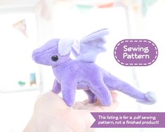 a hand holding a purple stuffed animal with wings on it's back and the caption saying sewing pattern, this listing is for a soft sewing pattern, not a finished product