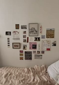 a bed covered in lots of pictures and papers on the wall next to a window