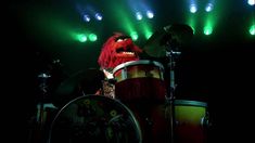 the muppet is playing drums on stage