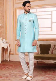 Art Silk Jacquard Asymmetric Sherwani in Sky Blue This Readymade attire with Satin Lining is Enhanced with Buttons, Brooch, Pocket and Resham Work. Crafted in Chinese Collar Neck and Full Sleeve Available with an Art Dupion Silk Pant in Off White Do note: Footwear shown in the image is for presentation purposes only. Brooch Design and Half to one inch in measurement may vary. (Slight variation in actual color vs. image is possible) Ceremonial Blue Bandhgala With Chikankari Embroidery, Blue Brocade Sets For Reception, Ceremonial Blue Sherwani For Transitional Season, Blue Traditional Nehru Jacket For Receptions, Ceremonial Blue Kurta With Chikankari Embroidery, Blue Chikankari Embroidery Kurta For Reception, Blue Kurta With Chikankari Embroidery For Reception, Blue Chikankari Embroidered Nehru Jacket For Reception, Blue Chikankari Embroidered Kurta For Reception