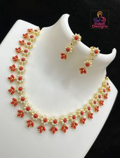 This traditional Gold Plated Exclusive Floral Motif Necklace boasts an exquisite design, with its pearls and red coral stones woven in an elegant flower pattern. Crafted with the finest Gold Plating and an intricate design, this piece is perfect for adding a touch of sophistication to any traditional saree. Carefully designed to make sure you stand out from the crowd. Coral Jewelry Design, Pearl Coral Necklace, Coral Gold Necklace, Kempulu Necklace, Gold Stone Necklace Designs, Coral Beads Jewellery Indian, Ruby Beads Jewellery Indian, Coral Necklace Indian Gold, Coral Necklace Designs