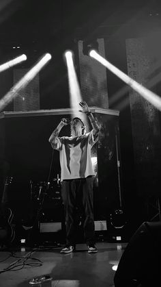 a man standing on top of a stage under spotlights