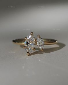 two gold engagement rings with one diamond on each side and the other in between them