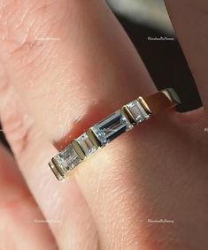 a woman's hand with a diamond ring on top of her finger, showing the band