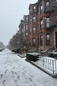 a snow covered street in front of some buildings