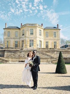 a bride and groom standing in front of a large building