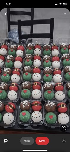 a table topped with lots of cupcakes covered in frosting and santa hats