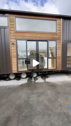 a tiny house on wheels with windows and sliding doors