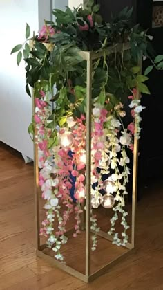 a planter filled with lots of flowers on top of a wooden floor