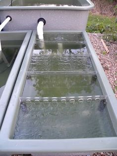 two sinks are shown in the middle of a garden with water flowing from them to the ground