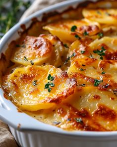 a casserole dish with potatoes and parsley in it on a tablecloth