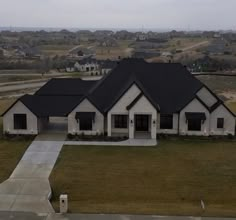 an aerial view of a house in the middle of a rural area with lots of grass