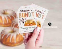 a person holding up two cards with donuts in the background