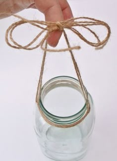 a hand holding a mason jar tied with twine