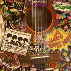 an acoustic guitar covered in stickers and decals