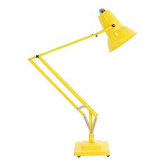 a yellow desk lamp on a white background with the light turned on and one arm extended