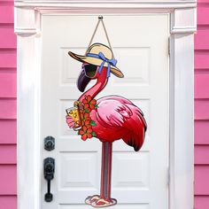 a pink flamingo door hanger with a hat and sunglasses on it's head