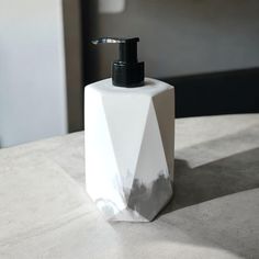 a white soap dispenser sitting on top of a table