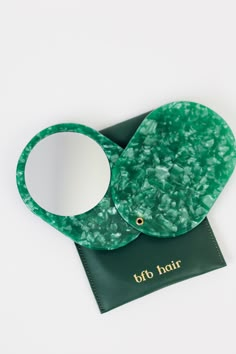 an elephant shaped mirror sitting on top of a piece of green paper with the words off to hair