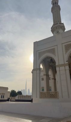 a large white building with a clock on it's side and a tower in the background