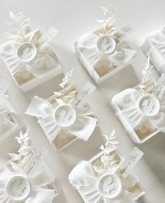 six white boxes with bows and buttons in them