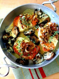 a pan filled with meat and mushrooms on top of a table